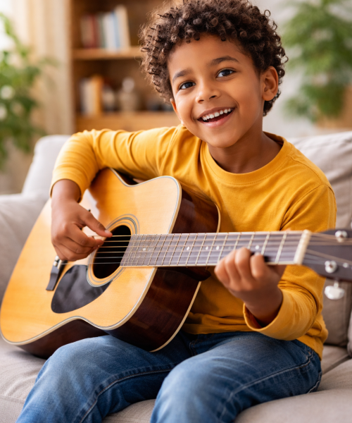 Joyful boy playing guitar in living room